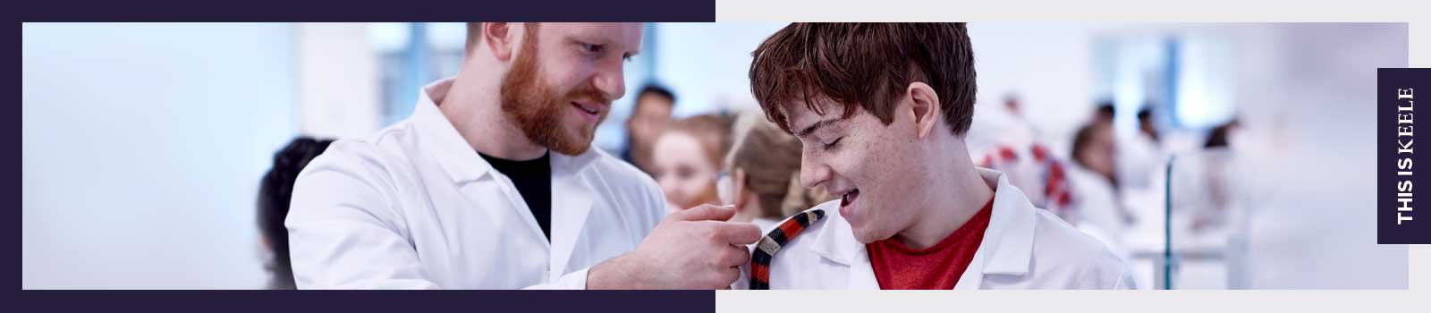 Student and teacher in laboratory holding snake