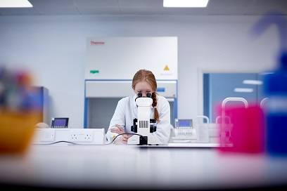 Biochemistry with Integrated Master's MSci student looking through microscope in Keele lab.