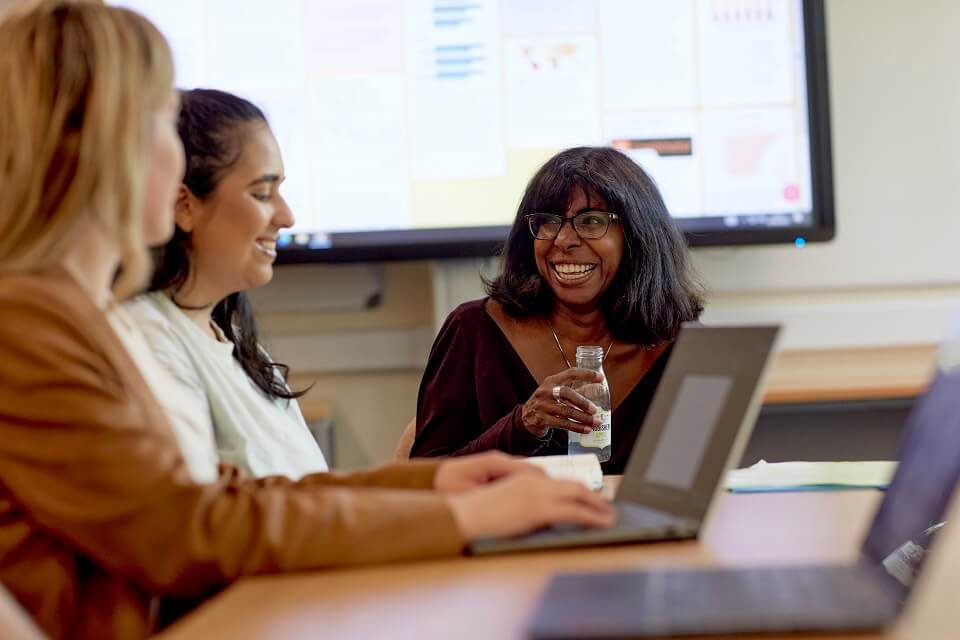 Students and staff having a discussion around the table